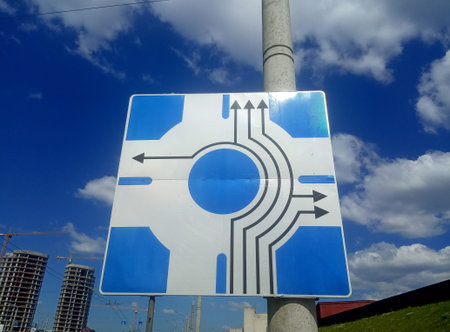 Road sign with arrows on a background of blue sky and white clouds