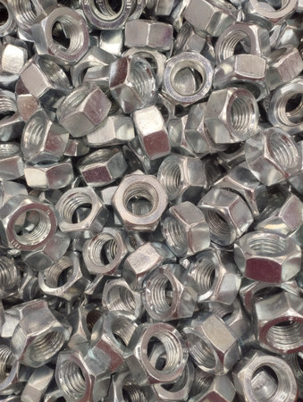 Metal nuts and bolts piled up together, closeup of photo.
