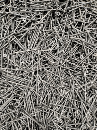 Screws piled up together as a background, close-up