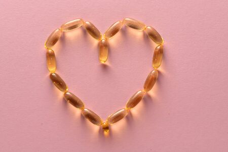 Close up capsules of fish fat oil in the heart shape, omega 3,の写真素材