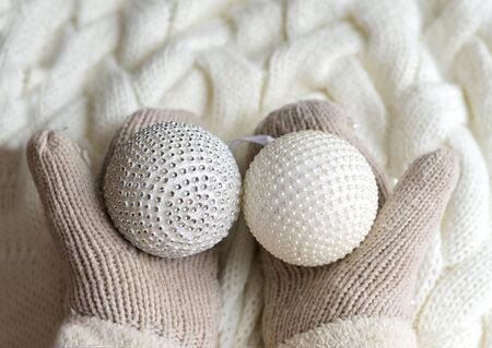 Christmas balls in the hands of mittens on a white knitted background. the concept of new year, Christmas , winterの写真素材