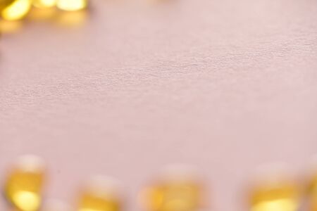 Close up capsules of fish fat oil in the heart shape, omega 3, vitamin Healthy food diet. blurの写真素材