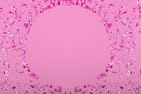 Pink confetti glitter on pink background, top view, copy spaseの写真素材