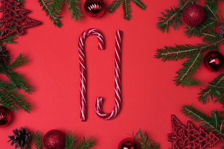Spruce branches, Christmas balls, candy on a red background, preparing for the New year and Christmas, top view Flat layの写真素材