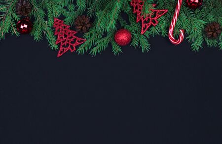 Spruce branches, Christmas balls, candy on black background, preparing for the New year. top view, copy spaseの写真素材