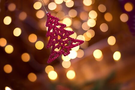 Closeup of red toy Christmas-tree decorations whith gold bokhe on buckground.の写真素材
