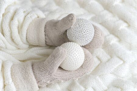 Christmas balls in the hands of mittens on a white knitted background. the concept of new year, Christmas , winterの写真素材