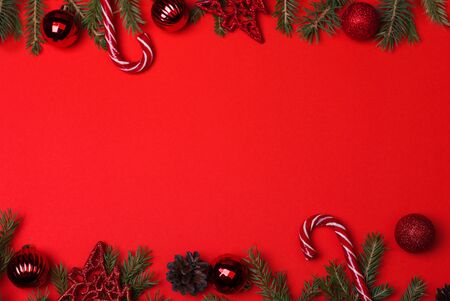 Spruce branches, Christmas balls, candy on a red background, preparing for the New year and Christmas, top view Flat layの写真素材