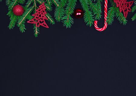 Spruce branches, Christmas balls, candy on a black background, preparing for the New year and Christmas, top view Flat layの写真素材