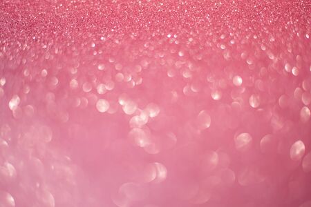 beautiful pink gold sequins on the glitter sparkle of sun light background with blur bright bokehの写真素材
