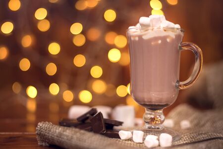 sweet cocoa in a glass with marshmallow on the background of bokeh lights, Christmas drink. Christmas decoration and bokeh of light in backgroundの写真素材