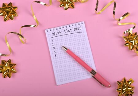 Pen writing in empty notebook decorated with Christmas decorations on the blue background. Top view, flat lay, copy spaceの写真素材