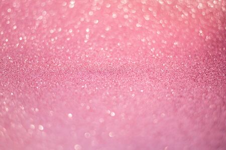 beautiful pink gold sequins on the glitter sparkle of sun light background with blur bright bokehの写真素材
