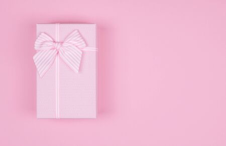 Pink rectangular gift box with pink ribbon on pink background. gift for March 8, Valentine's day, birthday. Top view. Copy space, mock upの写真素材