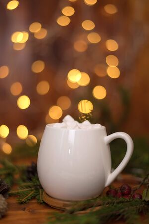 sweet cocoa in a white cup with marshmallow on the background of bokeh lights, Christmas drink. Christmas decoration and bokeh of light in backgroundの写真素材