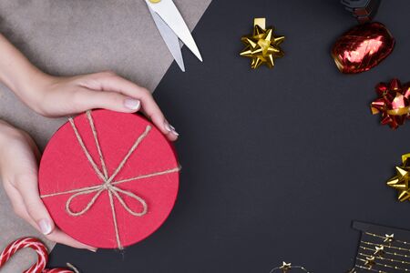Red round gift box on black background, new year and Christmas gift wrapping . top viewの写真素材