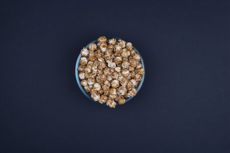 Caramel sweet popcorn bowl isolated on black background top view. Frame composition with copy space.の写真素材