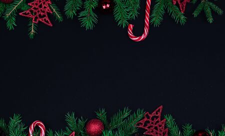 Spruce branches, Christmas balls, candy on a black background, preparing for the New year and Christmas, top view Flat layの写真素材