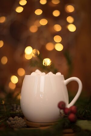 sweet cocoa in a white cup with marshmallow on the background of bokeh lights, Christmas drink. Christmas decoration and bokeh of light in backgroundの写真素材