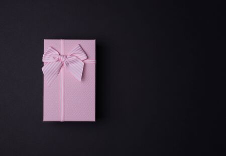 Rectangular pink gift box with bow on black background,の写真素材