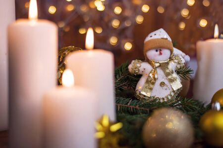 Christmas tree branches, with a snowman and a candle. Bokeh in the background. Christmas card. New Year 2020の写真素材