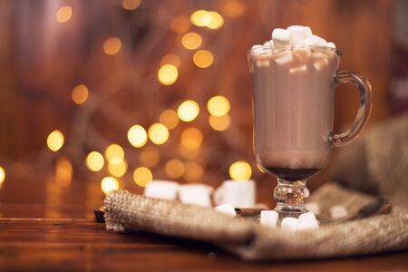 sweet cocoa in a glass with marshmallow on the background of bokeh lights, Christmas drink. Christmas decoration and bokeh of light in backgroundの写真素材