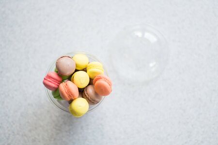 Mini macarons cakes in a package slide on a gray backgroundの写真素材