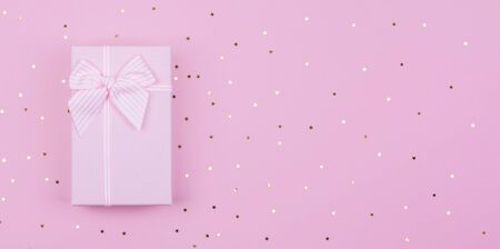 Pink Gift or present box and stars confetti on pink background. Flat lay composition for birthday New Year, copy spaseの写真素材