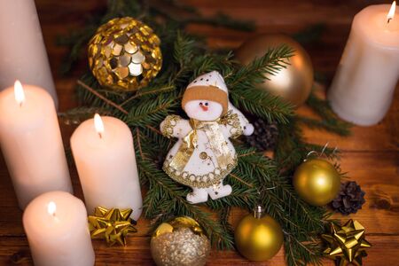 Christmas tree branches, with a snowman and a candle. Bokeh in the background. Christmas card. New Year 2020の写真素材