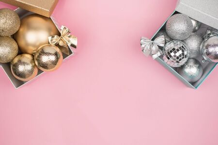 Gold and silver gift box with gold and silver Christmas balls on pink background, mock up, copy space, flat layの写真素材