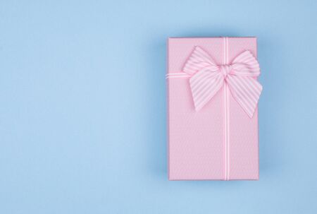 Pink rectangular gift box with pink ribbon on blue background. gift for March 8, Valentine's day, birthday. Top view. Copy space, mock upの写真素材
