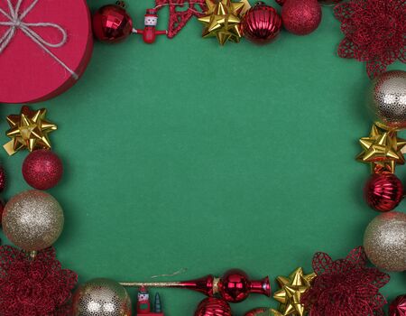 Red and gold Christmas balls on green background, top view, mock upの写真素材