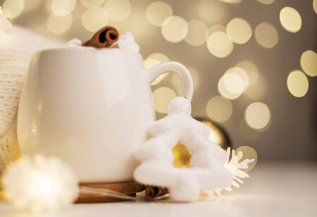 cup of hot cocoa with marshmallows and candy canes background with beautiful Christmas lights of bokeh. Cup of Coffee or capuchino on Blurred background.の写真素材