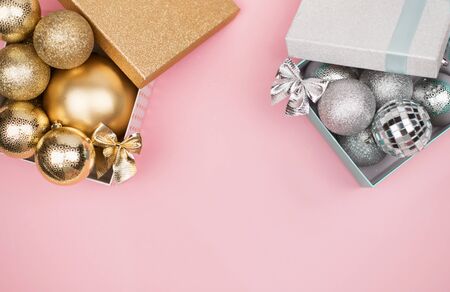 Gold and silver gift box with gold and silver Christmas balls on pink background, mock up, copy space, flat layの写真素材