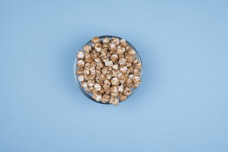 Caramel sweet popcorn bowl isolated on pink background top view. Frame composition with copy space.の写真素材