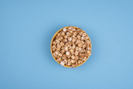 Caramel sweet popcorn bowl isolated on pink background top view. Frame composition with copy space.の写真素材