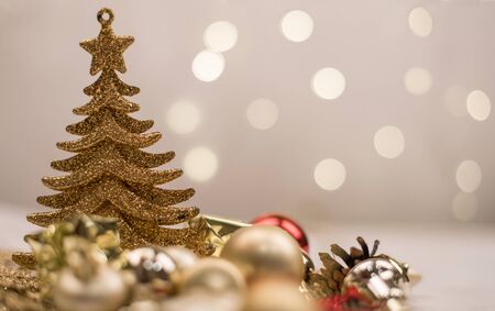 gold Christmas tree and balls on the background of bokeh lights on white backgroundの写真素材