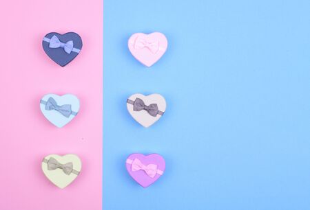 small multicolored gift boxes hearts on blue and pink background, Valentine's day gift, top view, copy spaseの写真素材