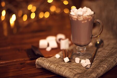 sweet cocoa in a glass with marshmallow on the background of bokeh lights, Christmas drink. Christmas decoration and bokeh of light in backgroundの写真素材
