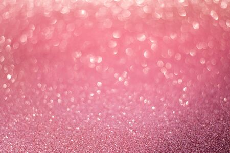 beautiful pink gold sequins on the glitter sparkle of sun light background with blur bright bokehの写真素材