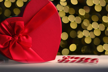 red heart gift box and two candles, candy red bokeh in the backgroundの写真素材