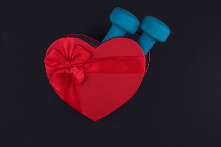 Gift for February 14 and March 8 in a beautiful box, dumbbells. The concept of losing weight with love. Sports equipmentの写真素材