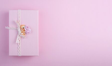 Rectangular pink gift box with bow and flowers on pastel pink background, gift on 8 march, top viewの写真素材