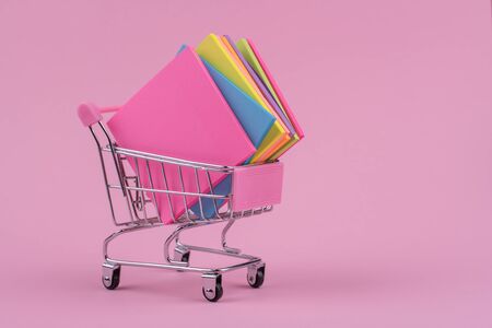 pink stationery grocery cart with colorful poems notes on a pink backgroundの写真素材