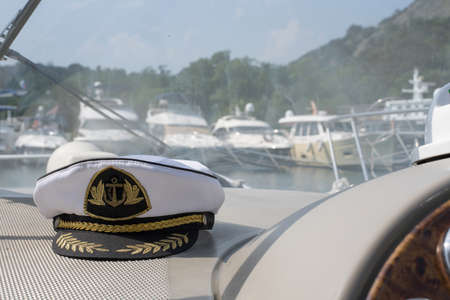 White sea captains cap on the dashboard of the boatの写真素材