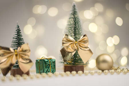 Little Christmas trees decorated and gifts for the new year on the bokeh background, new year mood 2021の写真素材