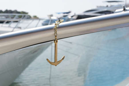 Sea golden anchor on the background of blured yachts in the seaの写真素材