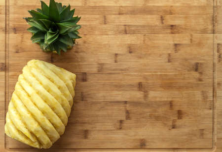 Ripe, juicy, yellow perfectly peeled pineapple, on a wooden background.の写真素材