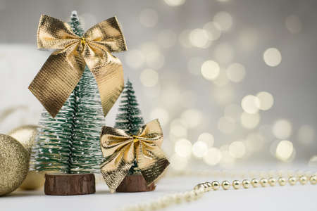 Little Christmas trees decorated and gifts for the new year on golden bokeh background, new year compositionの写真素材