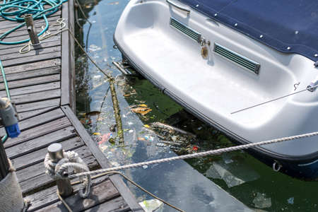 A disgusting pile of pollution floats in the sea under the boat.の写真素材